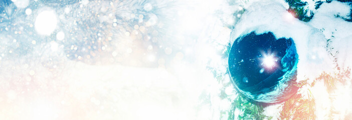 Winter background. The Christmas bauble. New Year's ball on the Christmas fir tree. Christmas shiny ball. Greeting card.