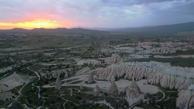 Drone aerial view showing stunning rock formations and fairy chimneys in Cappadocia during sunset in Turkey