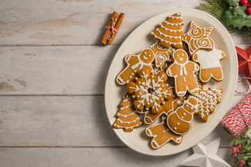 Holiday background. Christmas gingerbread cookies in different shapes in a plate, copy space