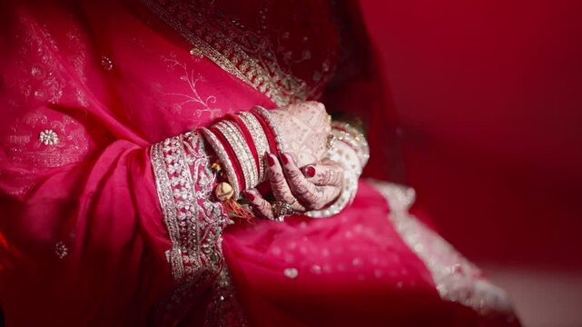 Close-up of female hands wearing traditional Indian bangles during a cultural ceremony. Detailed view of jewelry, hands movement, and ethnic accessories representing tradition, celebration, and Indian