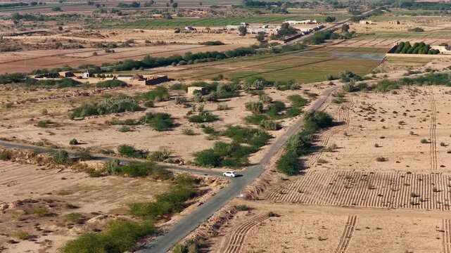 Drone captured cinematic views of the Cholistan Desert and Derawar Fort in Pakistan, vast golden sand dunes and historic fortress landscape filmed from an overhead aerial perspective during daytime, i