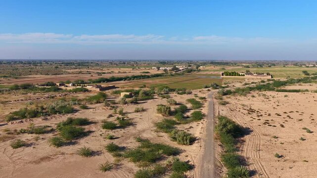 Drone captured cinematic views of the Cholistan Desert and Derawar Fort in Pakistan, vast golden sand dunes and historic fortress landscape filmed from an overhead aerial perspective during daytime, i