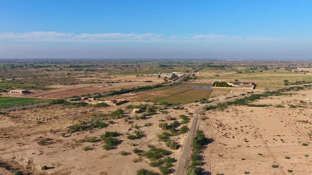 Drone captured cinematic views of the Cholistan Desert and Derawar Fort in Pakistan, vast golden sand dunes and historic fortress landscape filmed from an overhead aerial perspective during daytime, i