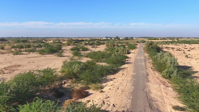 Drone captured cinematic views of the Cholistan Desert and Derawar Fort in Pakistan, vast golden sand dunes and historic fortress landscape filmed from an overhead aerial perspective during daytime, i