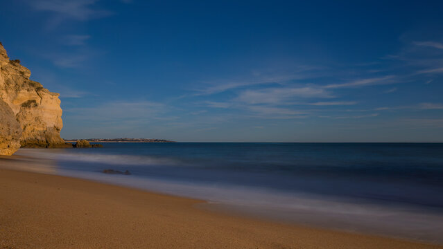 Langzeitbelichtung von einem Badestrand in Portugal mit wellen, Klippen und Brandung.