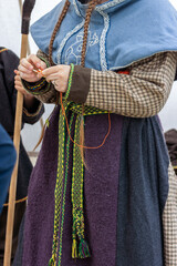 Frau ,Wikinger Tracht mit Borten beim Nadeln.