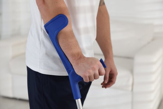 Man with elbow crutch at home, closeup