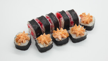 Sushi rolls and maki placed on a white surface in a simple arrangement showcasing colorful ingredients and unique toppings