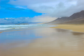 Obraz premium Aerial View of Cofete Beach and Cloudy Mountains in Fuerteventura