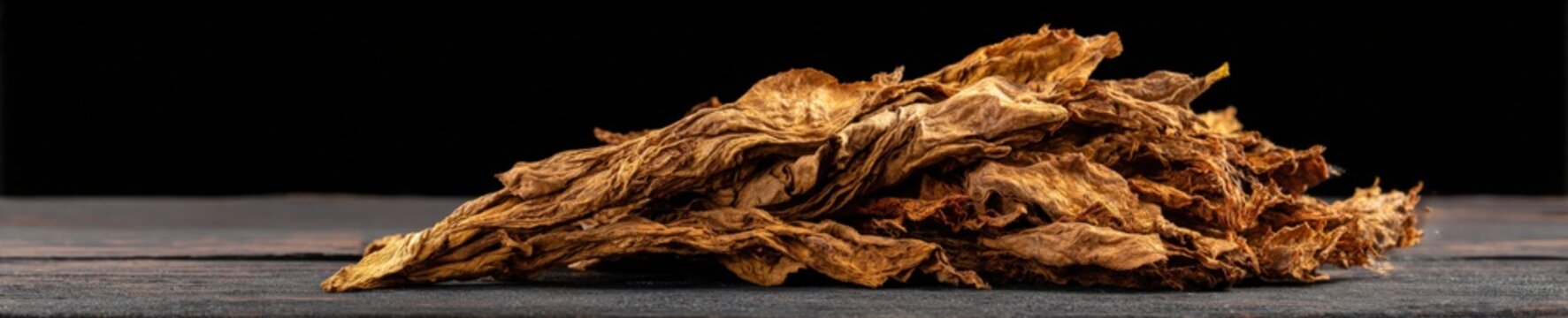 Dry tobacco leaves on dark wooden surface: natural textures and patterns
