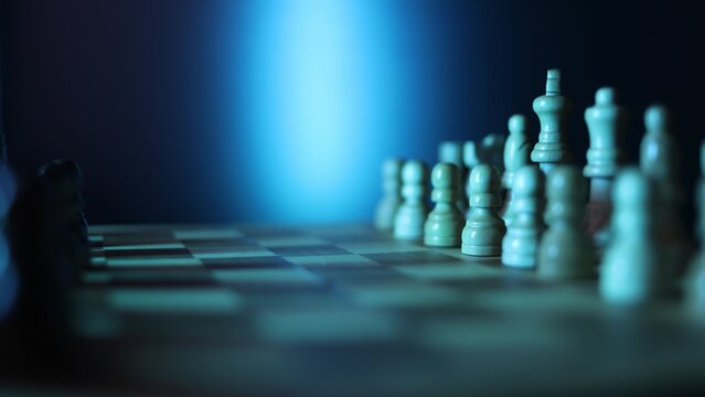 Dynamic video sequence of chess pieces positioned on a slowly rotating chessboard, symbolizing the intellectual confrontation between black and white opposing forces in strategic gameplay. Semi
