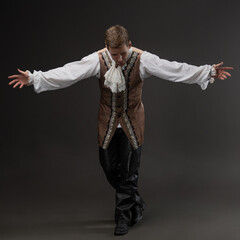 Baroque theatrical costume on young man, Shakespeare character portrait on gray