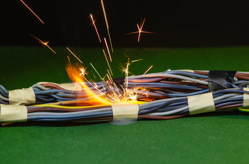 Bright electric sparks inside the bundle of wires indicate a dangerous malfunction of the electrical network.