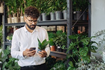 Man scanning potted plant in green flower shop