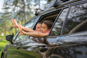 Group of Happy Children Waving and Reaching out of Car Window. High quality photo