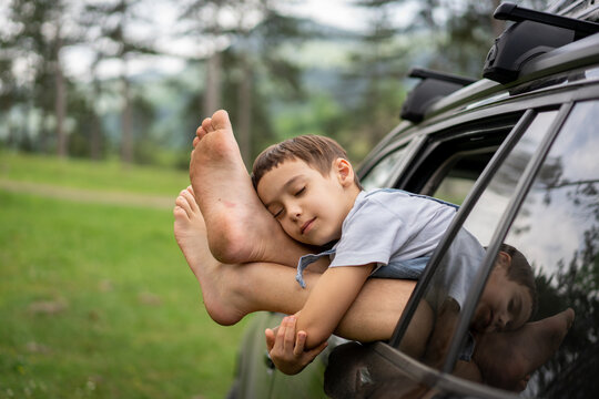 Content Child Resting Head on Car Window Frame in Nature. High quality photo