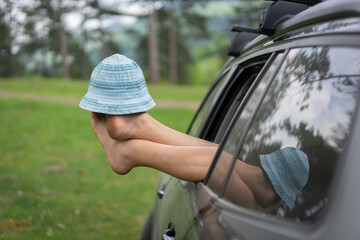 Funny Shot of Hat Balanced on Feet Out of Car Window. High quality photo