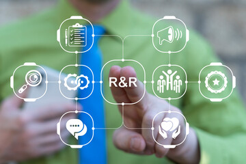 Business person using virtual touch screen presses the abbreviation R and R. R and R - Reward and Recognition Business Concept.