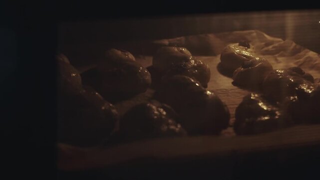 s-shaped yellow pastries, traditional Scandinavian holiday bakery with resins and chocolate raw dough ready for baking, being put in the oven. desaturated footage easily color matched