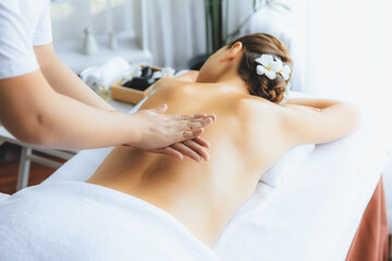 Masseur hands pouring aroma oil on woman back. Masseuse prepare oil massage procedure for customer at spa salon in luxury resort. Aroma oil body massage therapy concept. Quiescent