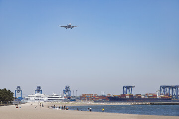 城南島を通過する船舶、飛行機、浜で遊ぶ人々