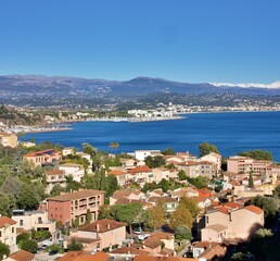 Fototapeta premium Stunning panoramic winter landscapes of the French Riviera, featuring the coastal towns of Cannes and Théoule-sur-Mer. The Mediterranean Sea contrasts beautifully with the snow-covered mountains
