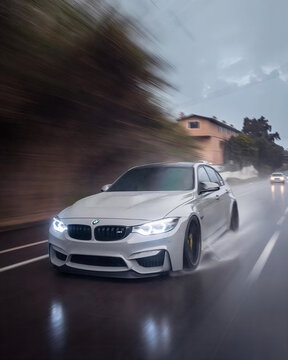 BMW M3 F80 driving on wet road in rain