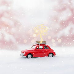 Red toy car with Christmas tree on snowy background winter holiday concept