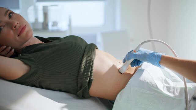 Closeup doctor examining ultrasound pregnancy clinic. Hand using medical machine