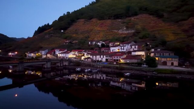Belesar village with autumn vineyards reflecting in the tranquil mi&ntilde;o river