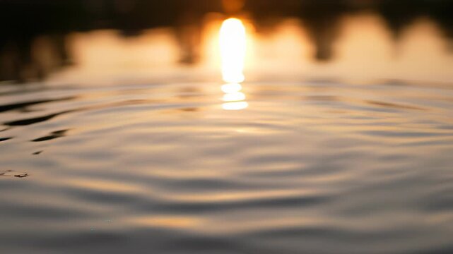 Tranquil lake setting with serene water drop, reflecting golden sunset hues and peaceful atmosphere, embodying the concept of unifying forces and energies, perfect for use in ufa themed projects.