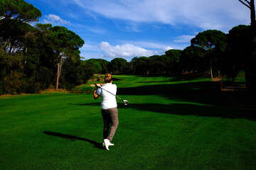 Obraz premium woman playing golf in the green fairway club