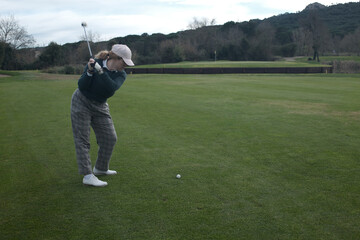 woman playing golf in the green fairway club