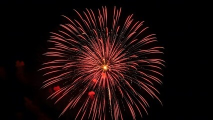 Vibrant red fireworks exploding in night sky with bright sparks