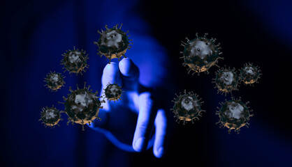 Abstract conceptual image depicting the spread and threat of Coronavirus. A hand reaches toward virus particle