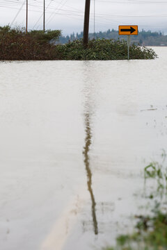 A right turn sign stands out above floodwater on a city street. The flood was the result of heavy rain and extreme weather in Washington state. 