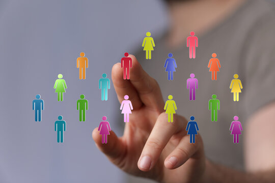 Hand touching colorful icons representing diverse people, teamwork, collaboration, and community engagement. Digital connection concept.
