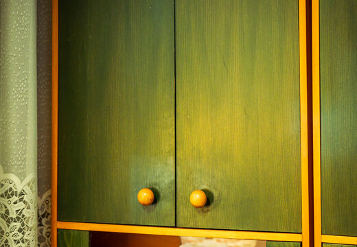 Vintage green wooden cabinet with round yellow knobs