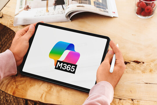 Person holding tablet displaying microsoft 365 logo
