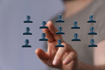 Hand pointing towards a network of abstract human icons, representing teamwork, collaboration and...