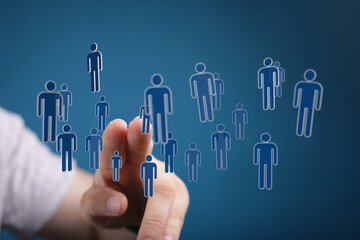 Hand interacting with virtual human figures representing networking and business connections, teamwork, and soc