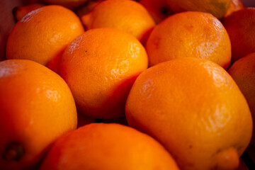 Lemons are stacked in a basket showing bright yellow colors