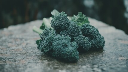 Fresh broccoli florets on a stone surface.