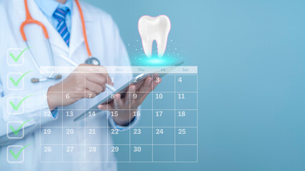 Dentist in white coat using tablet with glowing tooth icon and dental care calendar, oral health planning concept, modern dentistry, digital healthcare technology, copy space.