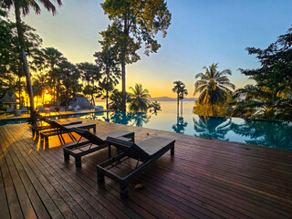 Obraz premium Stunning sunset over Koh Phayam Island revealing tranquil poolside paradise