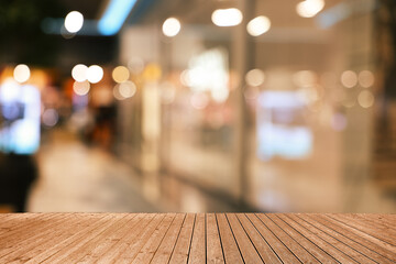 Empty wooden table against blurred view of shopping mall. Space for design