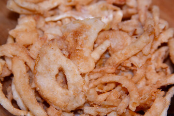 A close-up of  crispy, golden, French-fried onions.