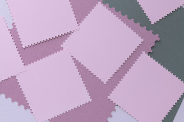 blank pink paper tiles with perforated edges randomly arranged on paper