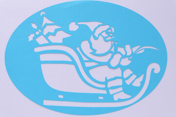 blue paper oval with cutout of Santa on a sleigh