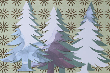 stylized paper trees machine-cut from marbled paper and arranged in layered form on scrapbooking paper with floral decor
